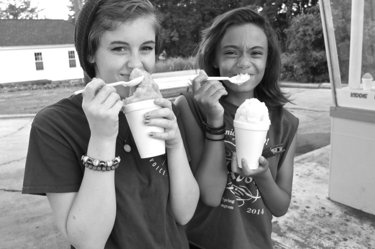 black and white image of two teenage girls eating snow cones