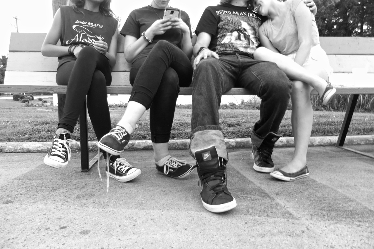 black and white photo of teenagers feet