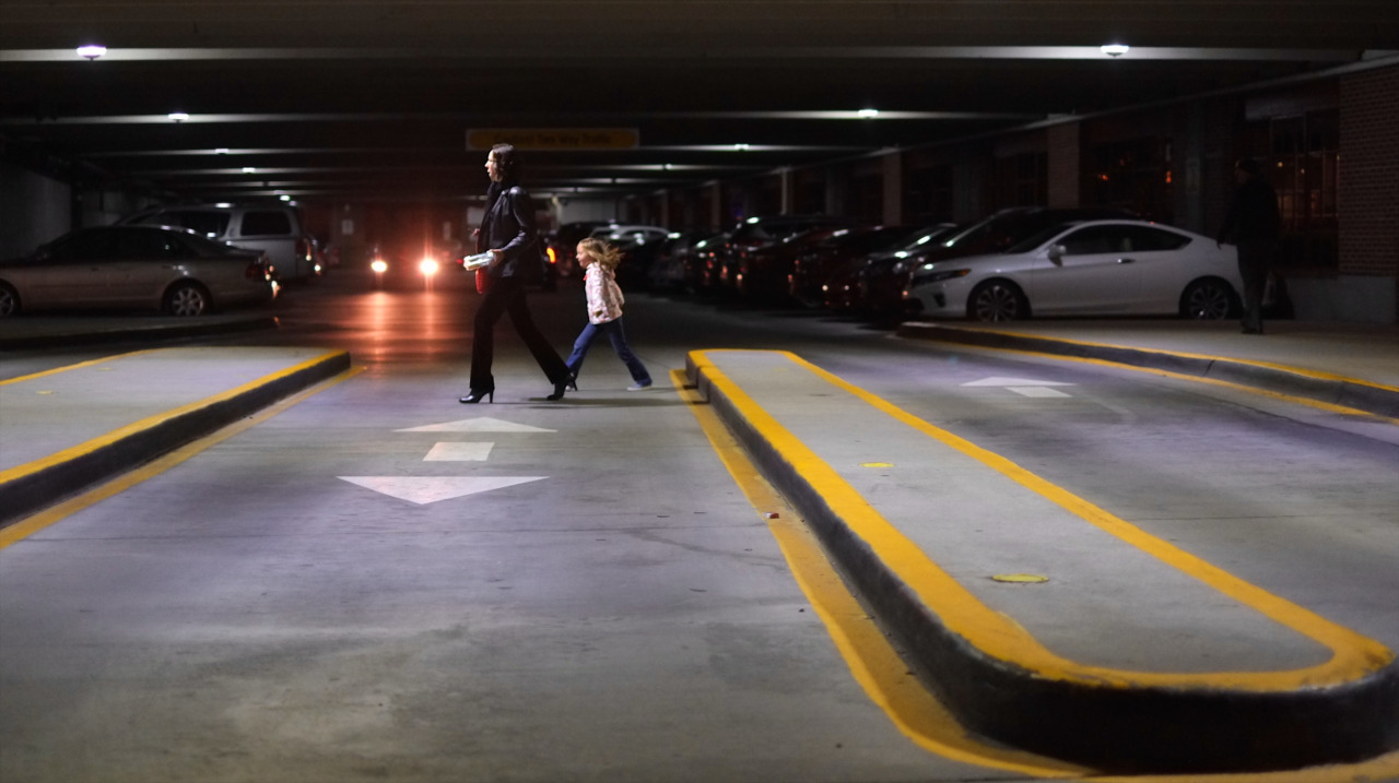 photo of a mom and child walking in a parking garage