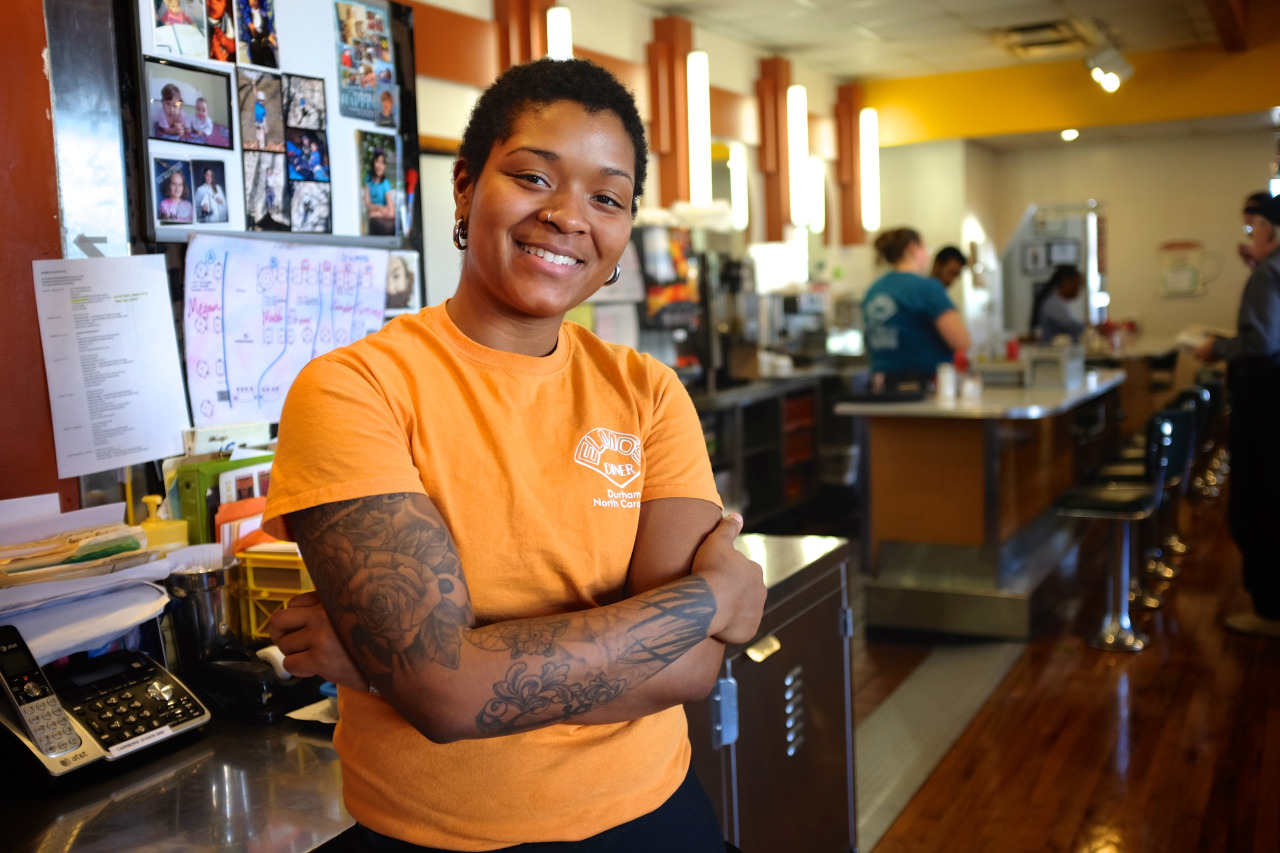 young african-american waitress with tattoos smiling