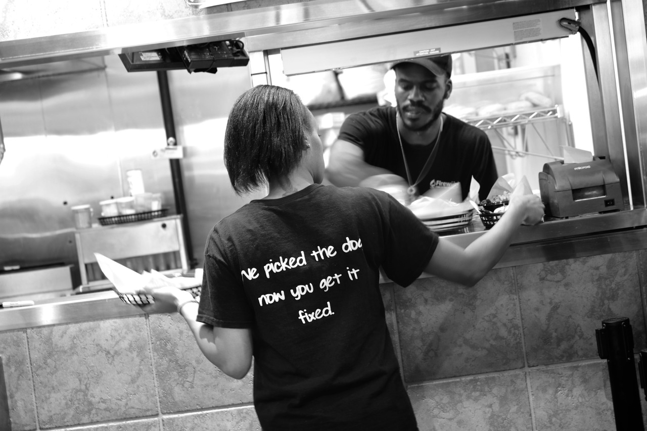 girl at hot dog shot with a slogan on the back 'we picked the dog, now you get it fixed.'