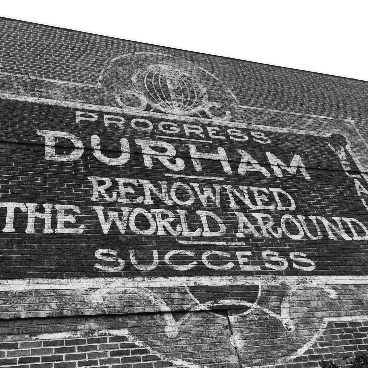 Reproduction of a historic Durham NC sign saying: Progress. Durham Renowned the world around. Success. 