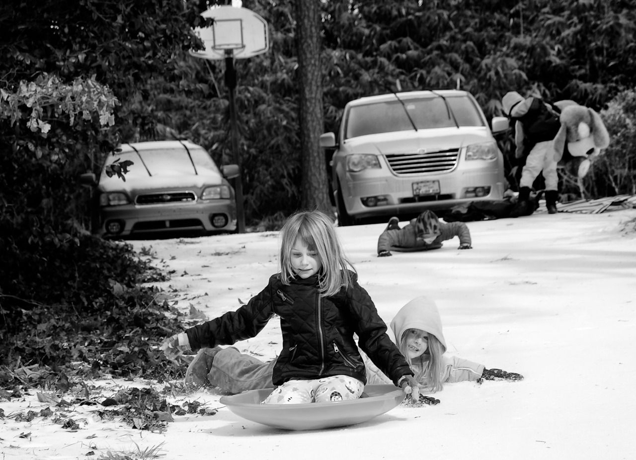 photo of child sliding in the snow