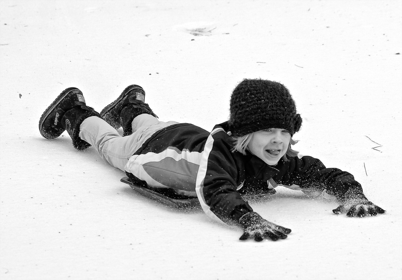 photo of child sliding in the snow