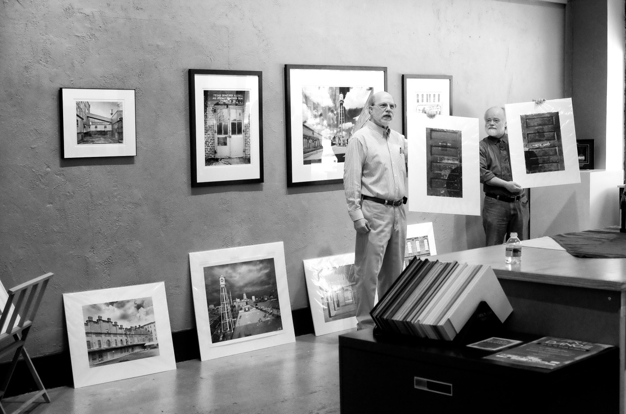 monochrome image of a man at a photo art gallery giving a talk