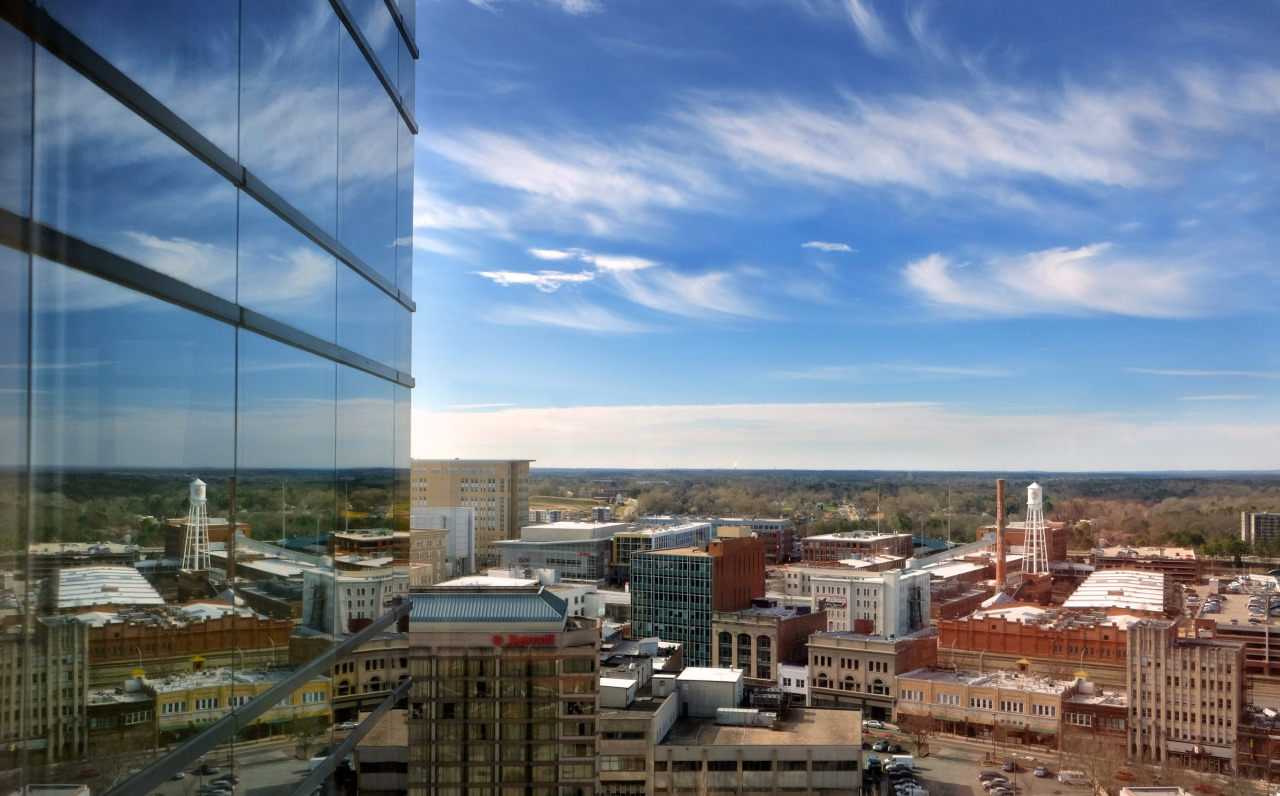 view of Durham from up in the tallest building in Durham with blue sky and reflective windows