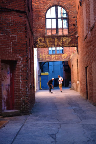 photo of two teen boys in a colorful alleyway