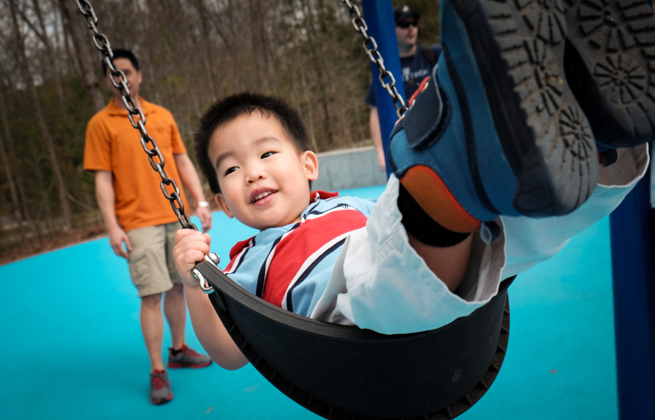 photo of a young asian boy smiling on a swing