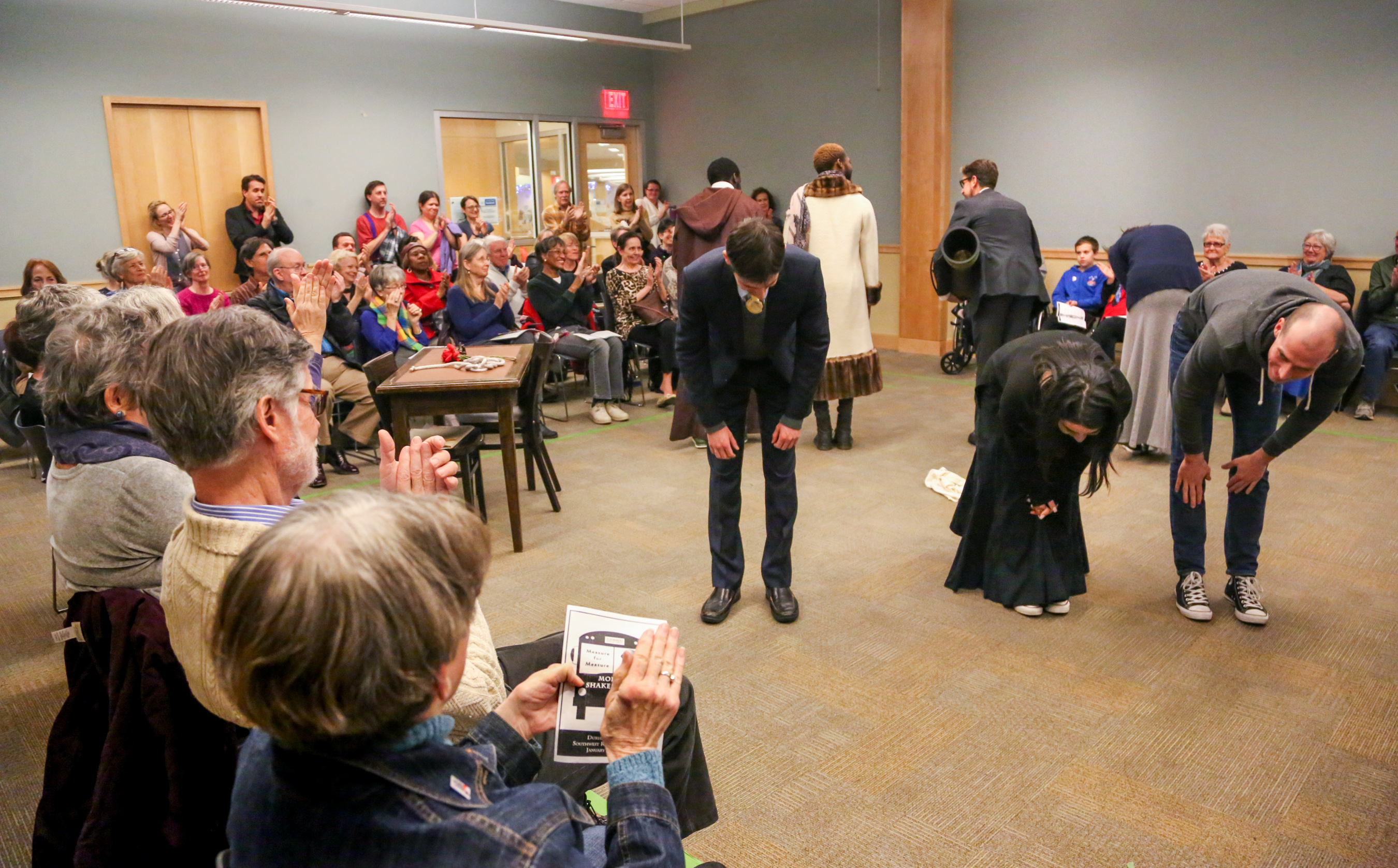 actors get an ovation after performing Shakespeare in a library setting