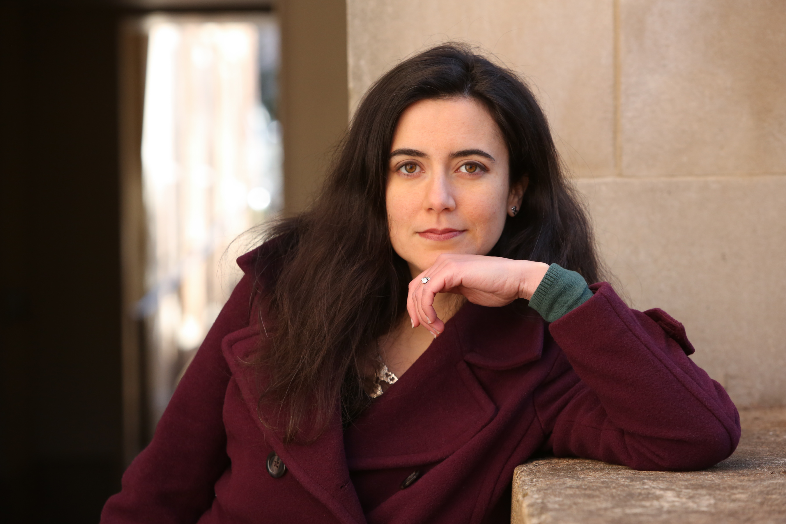 photo of a woman in a red jacket looking seriously at the camera