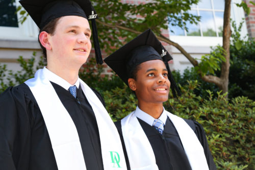 Image of two grad boys looking proudly up to the sky