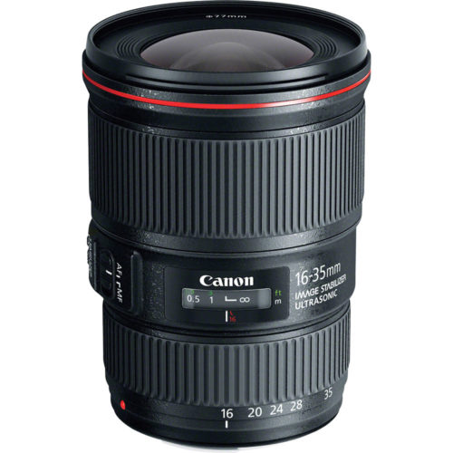 Photo of a black canon lens sitting up with a red ring on the end