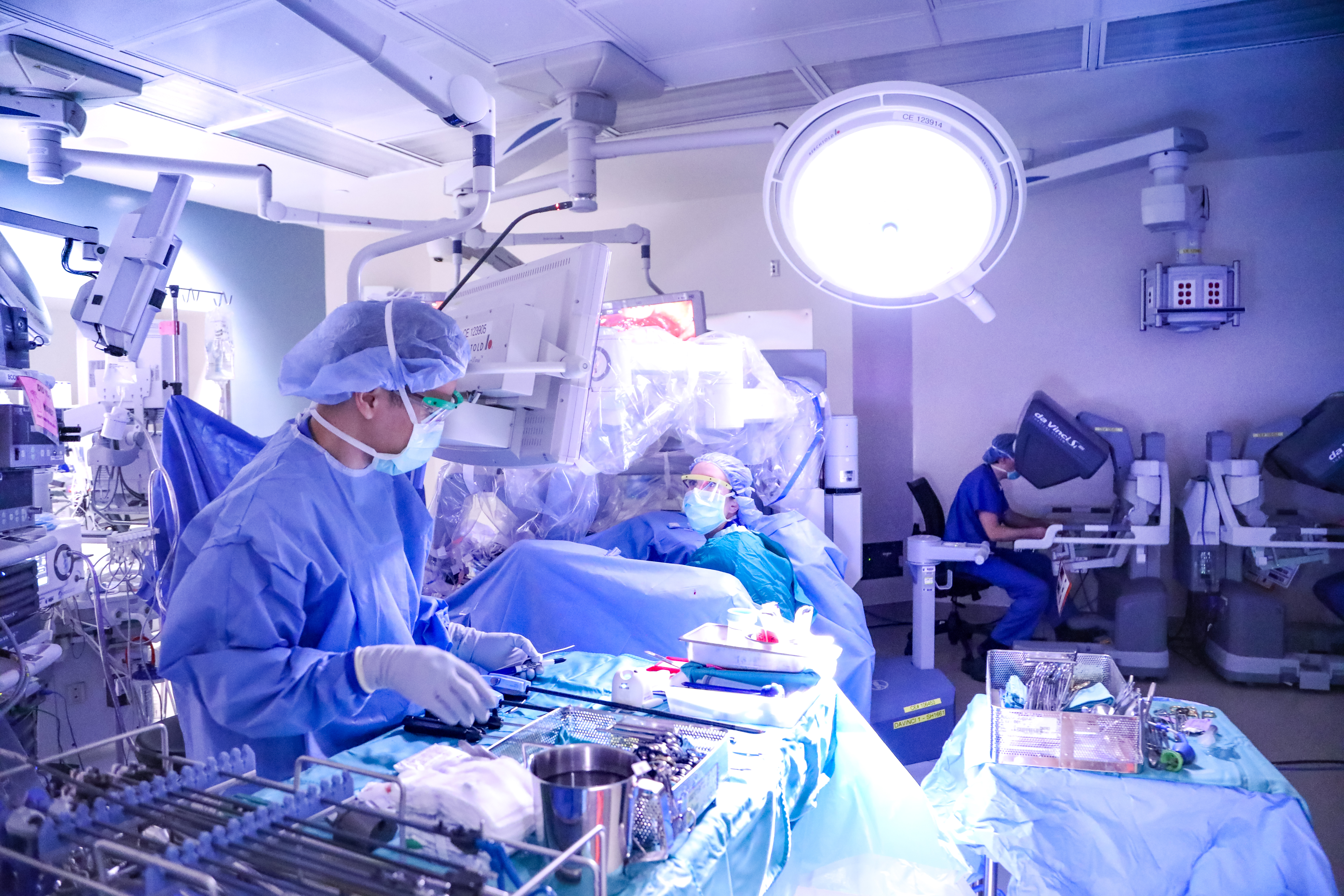wide view of surgery with two Da Vinci robotic surgery controllers