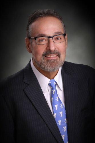 portrait of a businessman with a dark studio background behind him