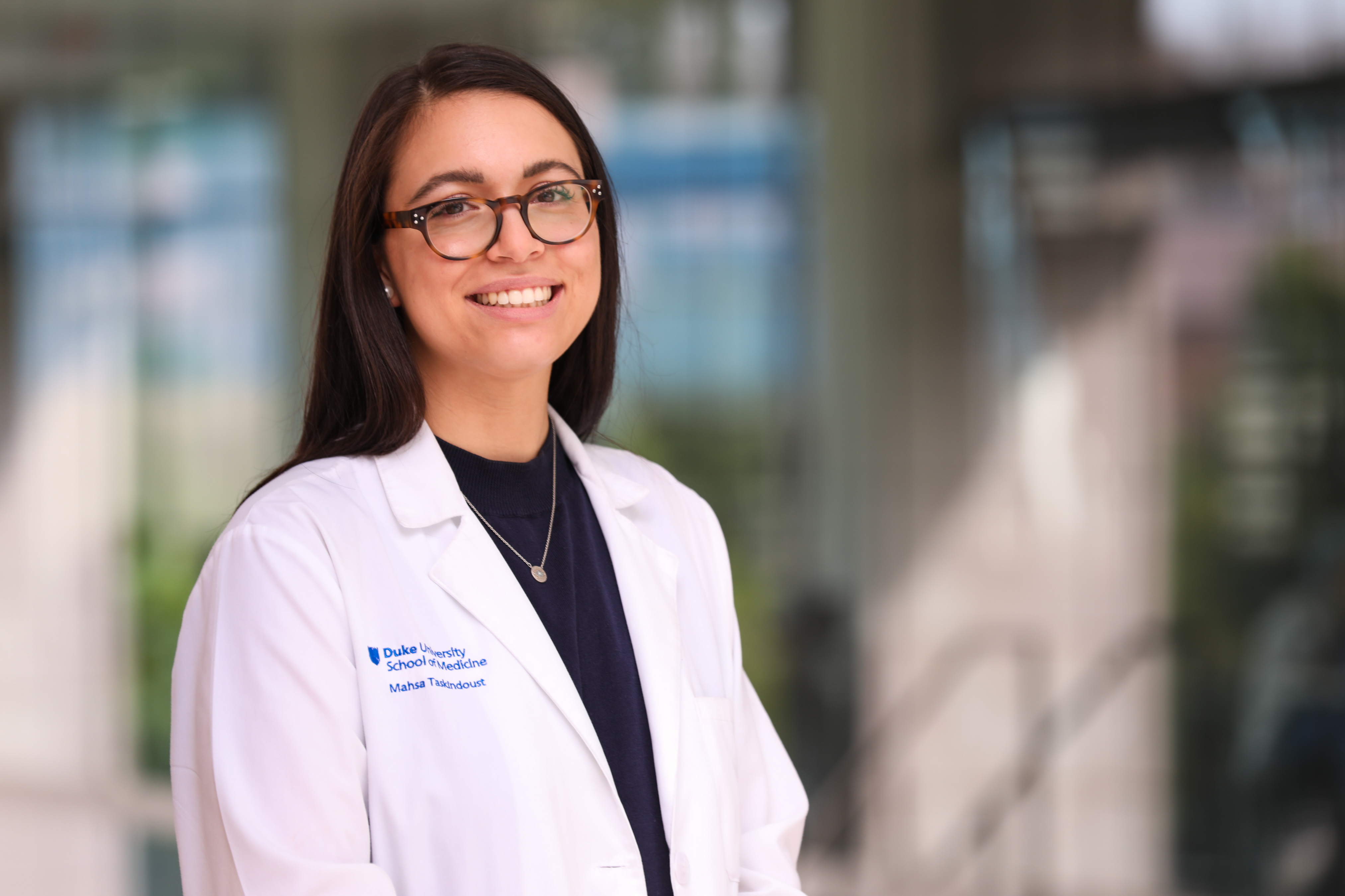 portrait of a female doctor with a soft modern building background behind her