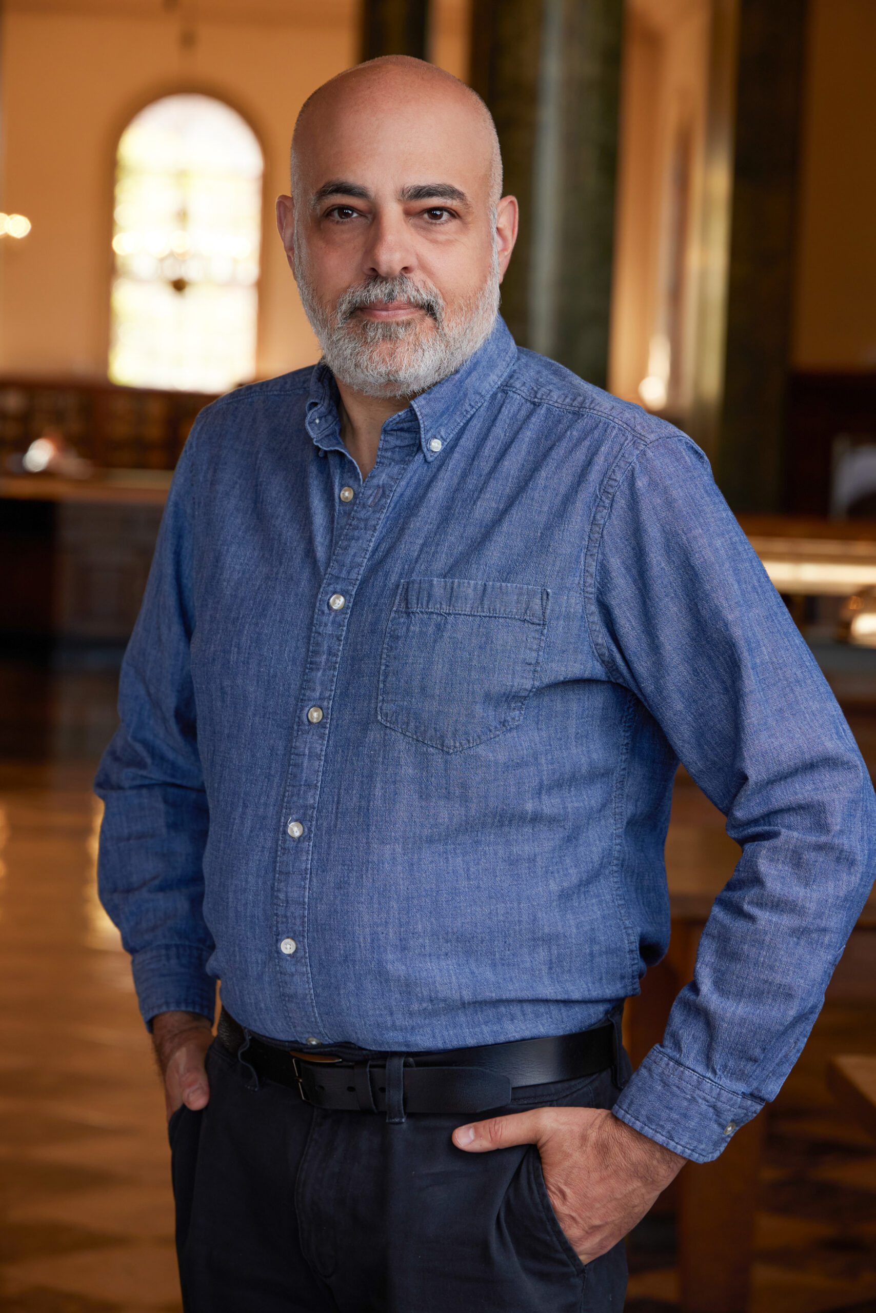 portrait of a confident man in a casual shirt in a warm library location