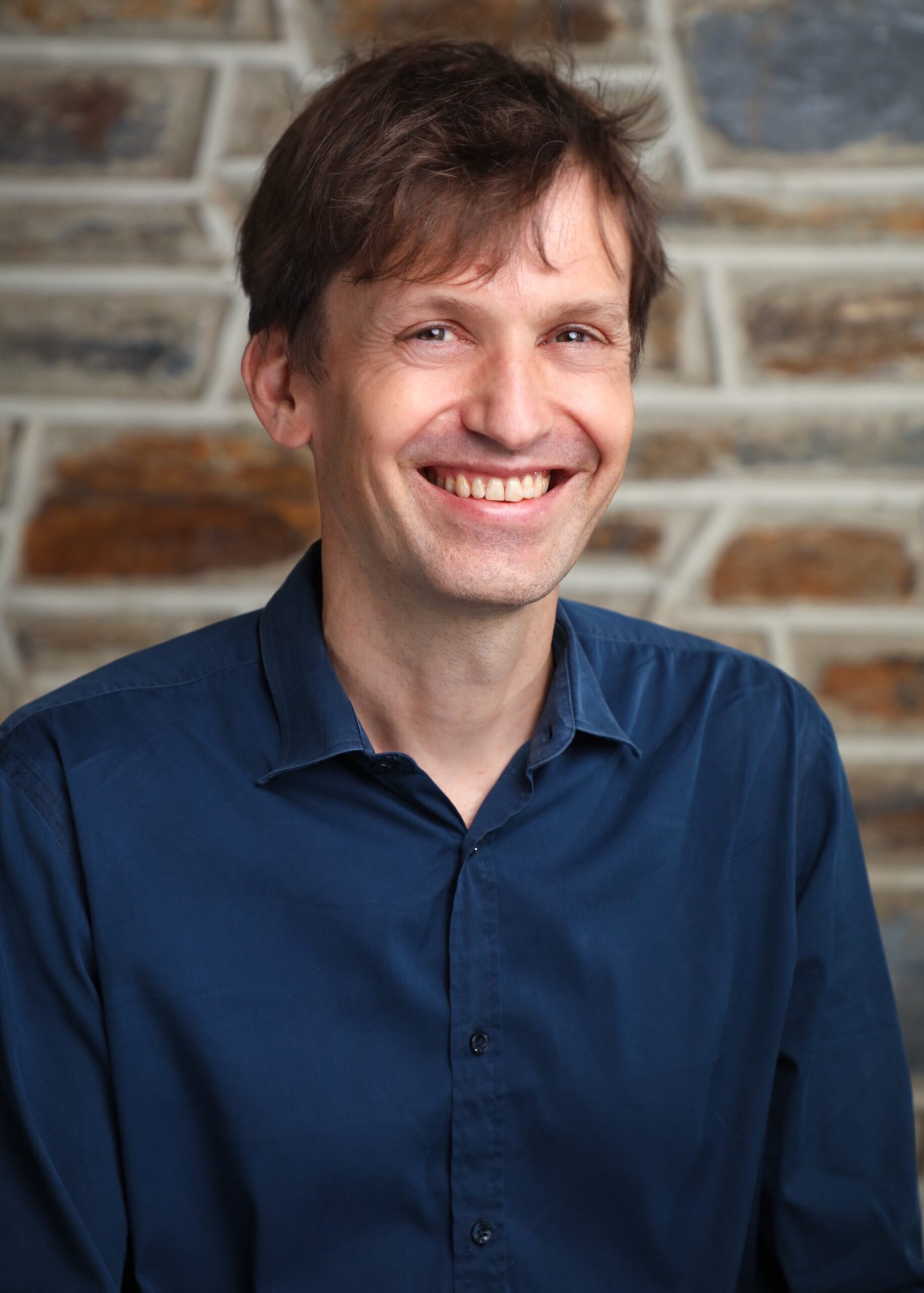 portrait of a man smiling at the camera with a nice Duke Stone background