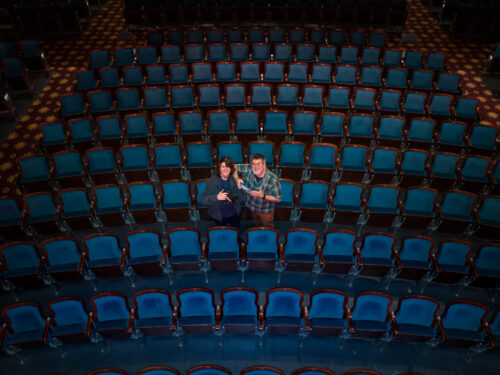 overhead image taken by drone of Ken & Oliver Huth in a sea of blue theatre seats at the historic Carolina Theater Durham