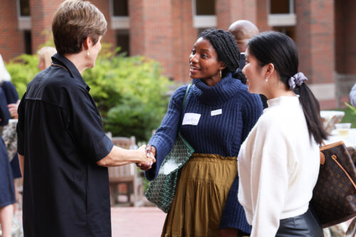 Two women shake hands at the 100 Women Event at UNC Kenan Flagler Business School.