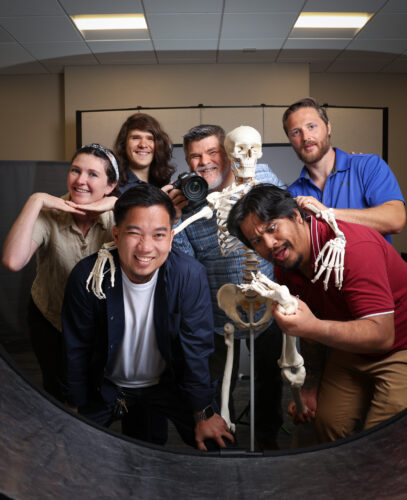 group of photographers making faces with a skeleton in the group.