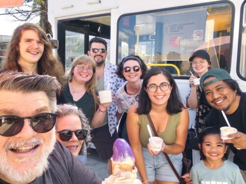 group photo of a mostly young group at an ice cream truck smiling