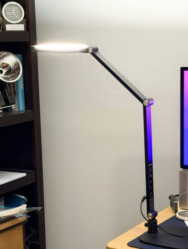 modern black LED desk lamp with the light pointed toward the ceiling creating a nice glow